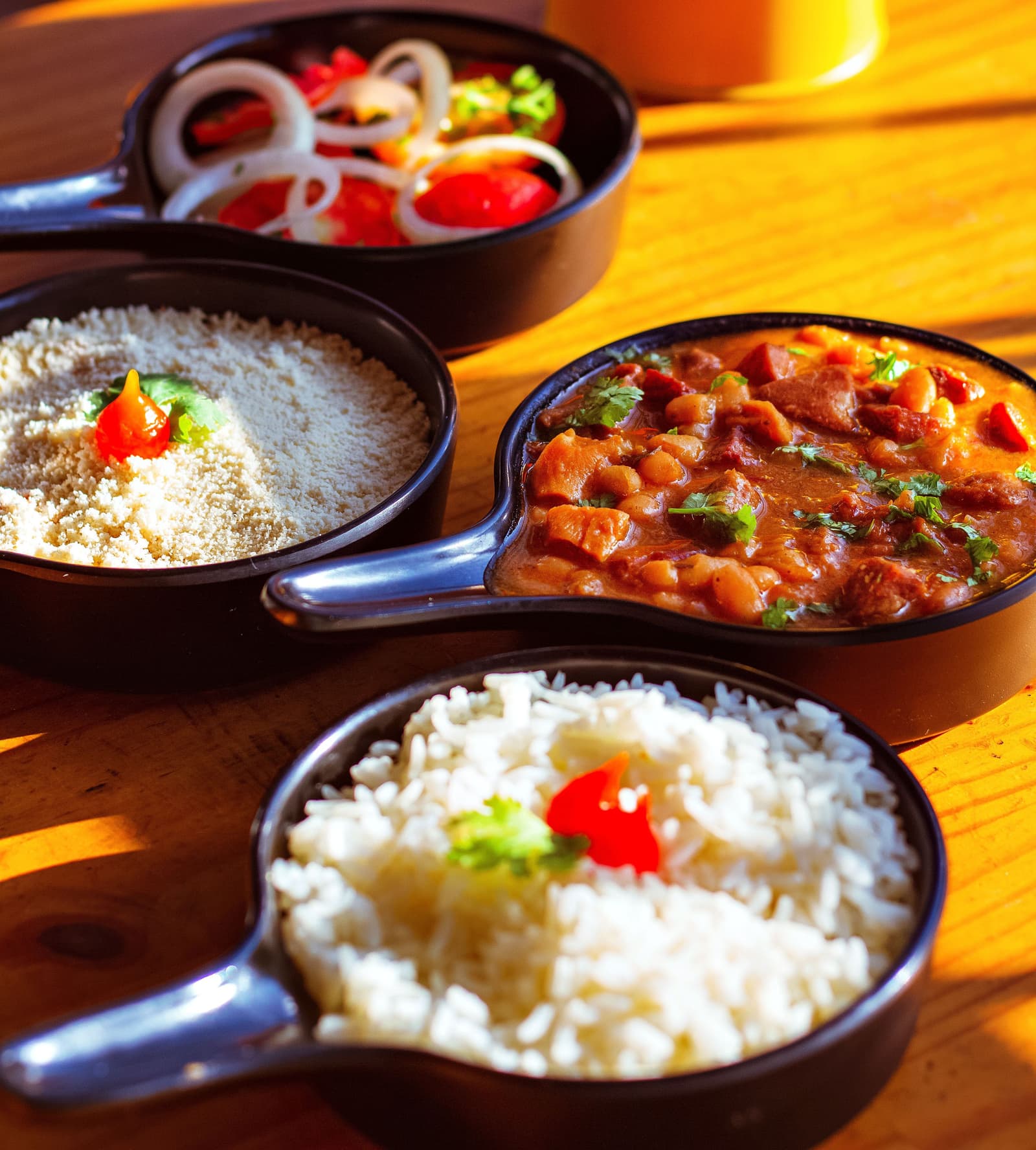 Panelinhas com feijão com linguiça, farofa, arroz e vinagrete