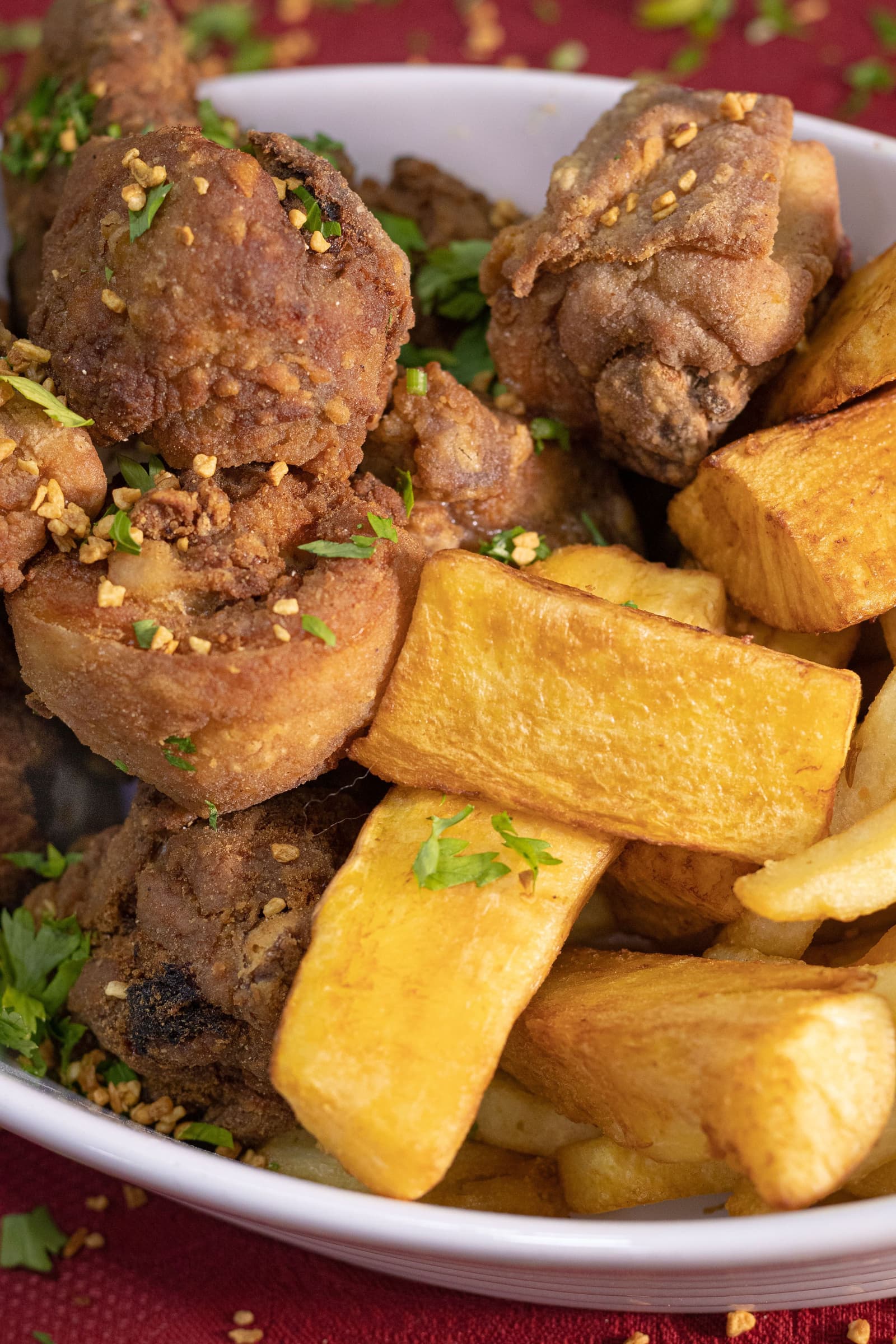 Tigela com carne frita crocante e mandioca frita dourada